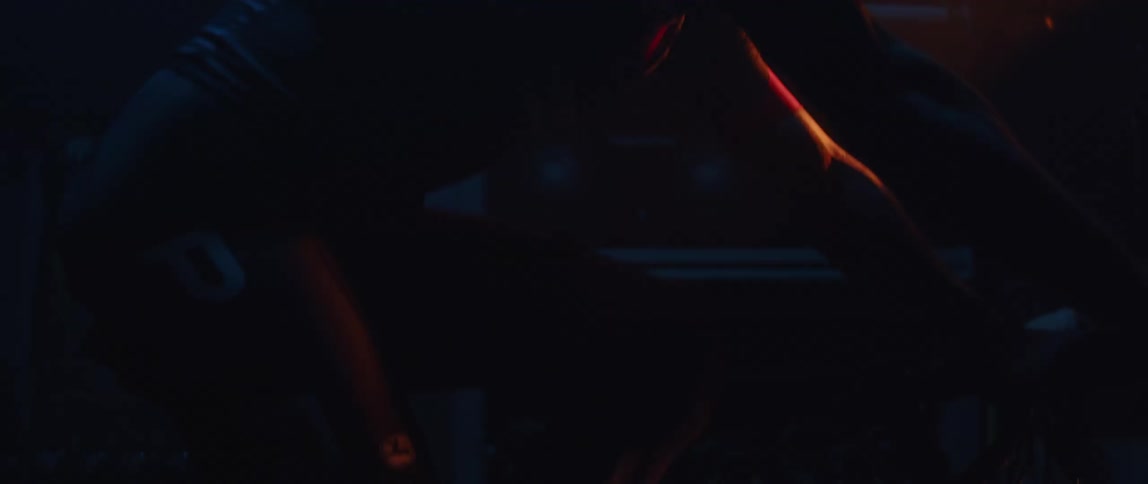 A man riding a stationary bike in darkness