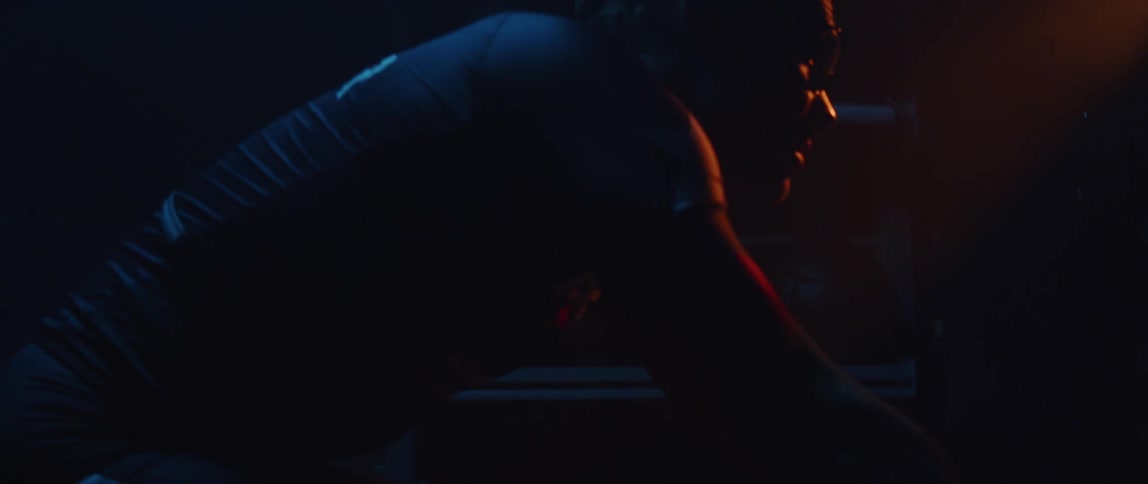 A man riding a stationary bike in darkness