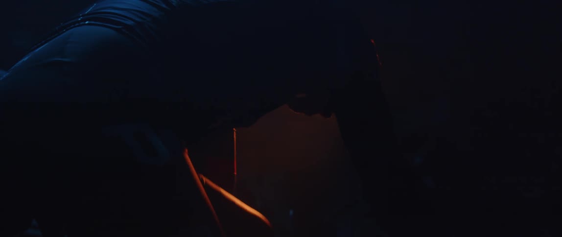 A person is pedaling on a bike outdoors at night