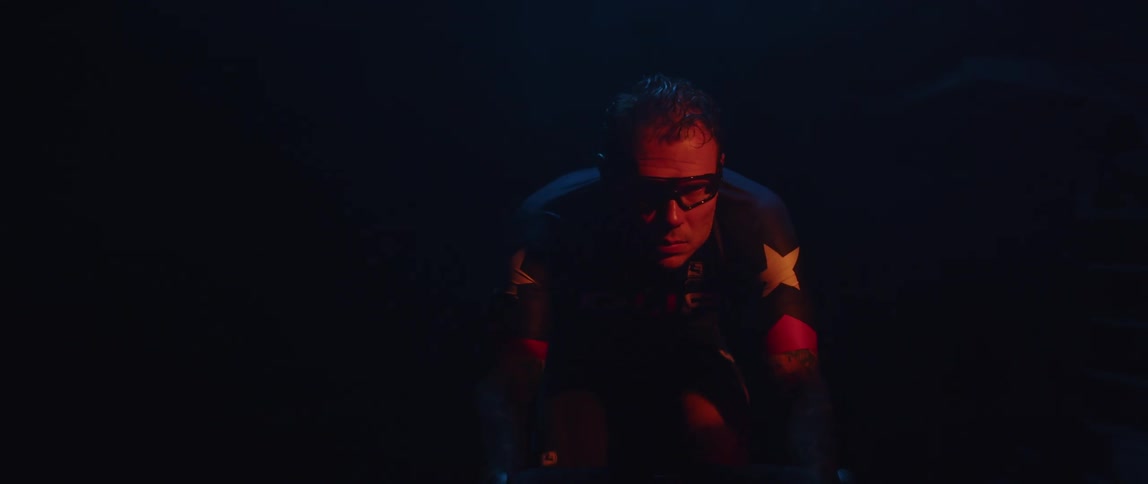 A man riding a stationary bike in a dark room