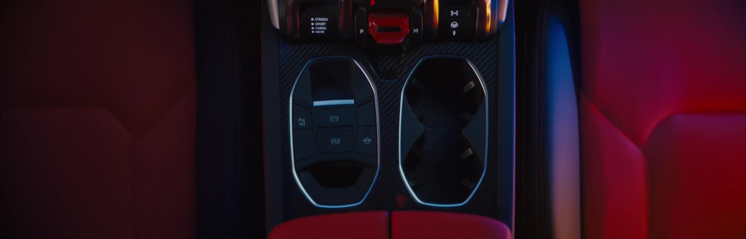 Red upholstered seats flank center console of vehicle