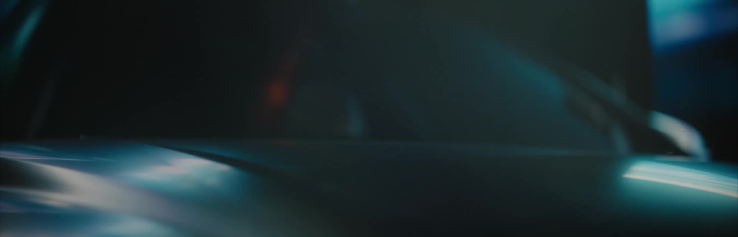 Color lights reflect off a sports car parked indoors