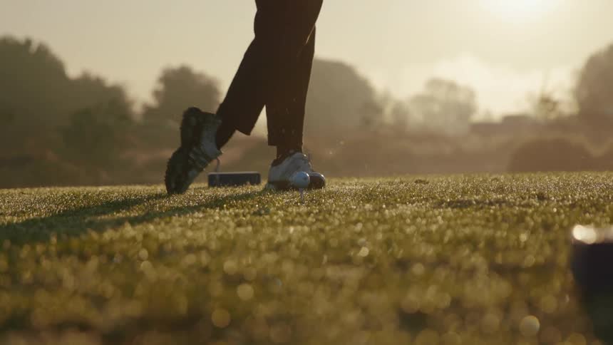A man practices his golf swing on a course