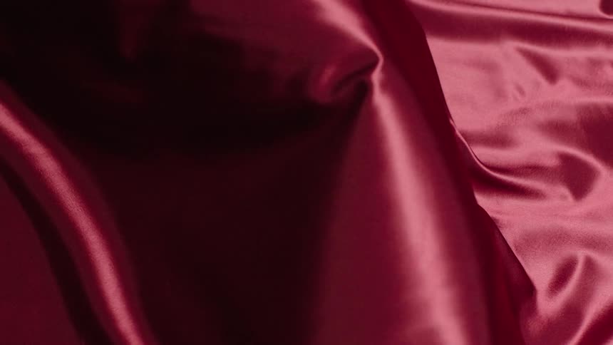 A shiny piece of fabric is blown by airflow that causes it to billow