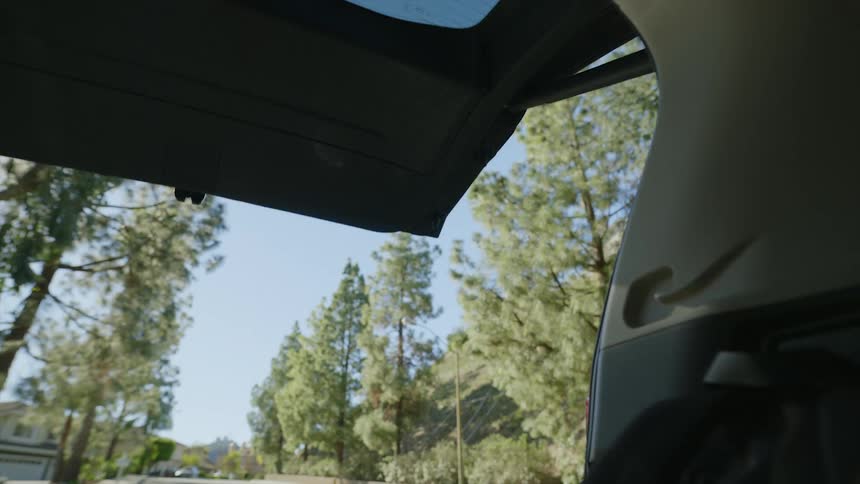 Man places backpack in vehicle and closes hatchback