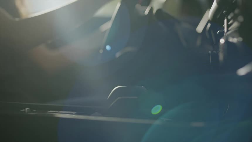 A woman is sitting in a car and driving it