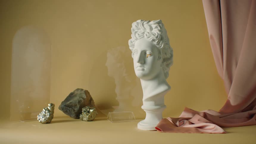 Teardrop decorates eye of bust placed among rocks