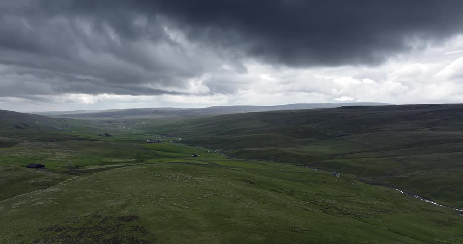 A creek runs at the bottom of rolling hills