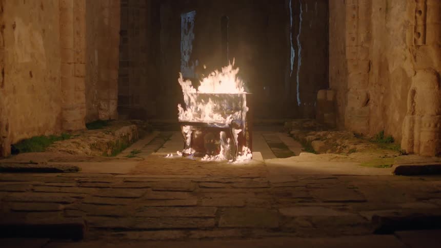 A piano is engulfed in flames and burning in an abandoned building