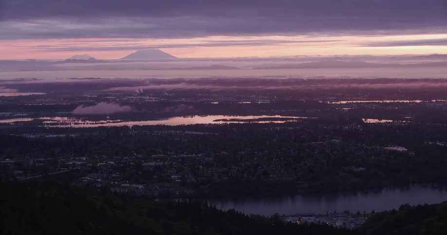 The silhouette of mountains on the horizon with neighborhoods and city buildings on islands and waterfront
