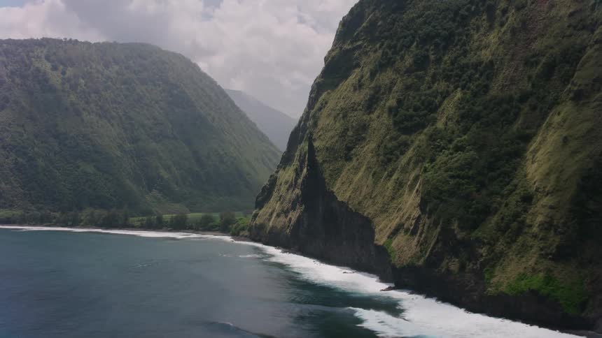 Waves crash onto the shore below steep cliffs