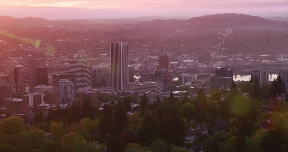 Setting sun turns mist red as it shines onto city in valley