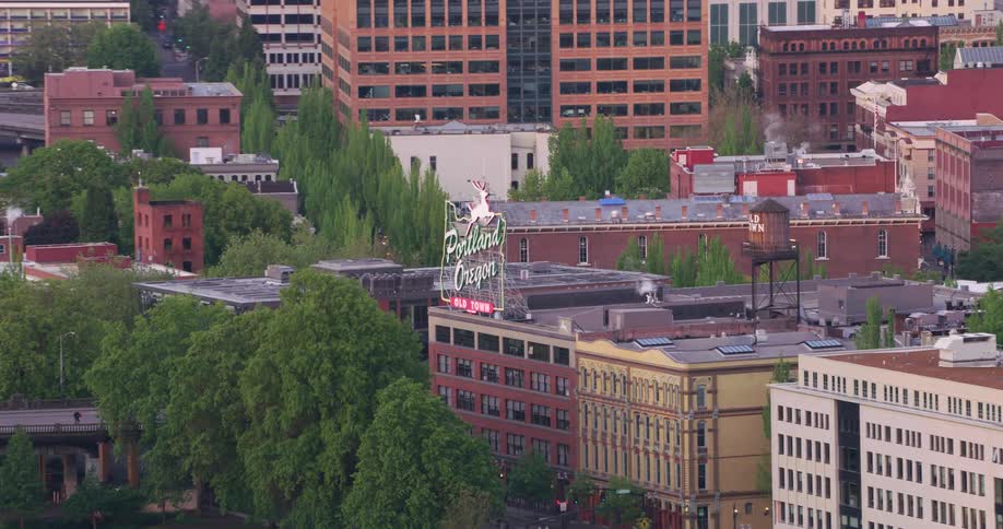 Traffic moves across a bridge entering the city and traveling past buildings in portland oregon