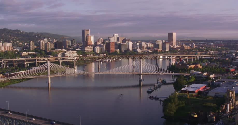 Vehicles cross bridges over a river near downtown