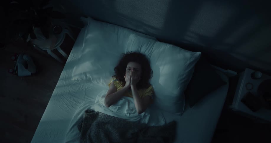 A woman sleeping in a bed at night