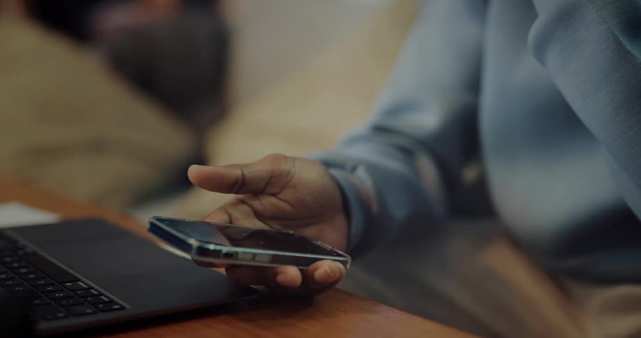 Man holding a phone in his hand uses his thumb to scroll the screen