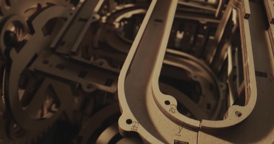 Close up of the turning gears of a complex machine with metal balls running through pipes