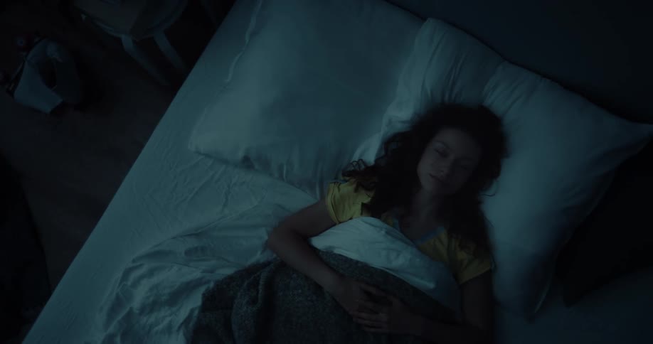 A woman lying in bed on her back wide awake