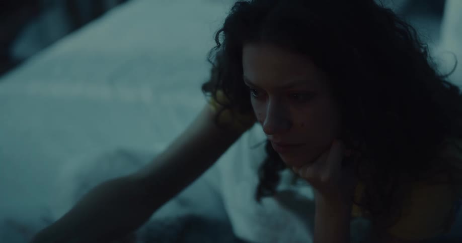 A woman sits up in bed