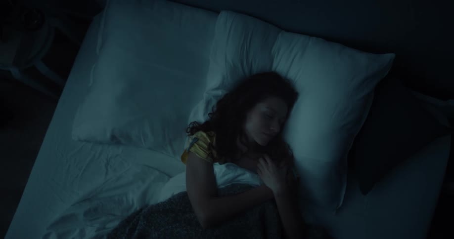 A woman goes to sleep in bed