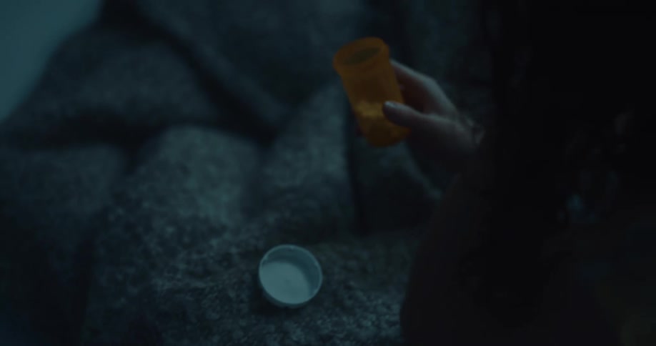 A woman takes pills in bed