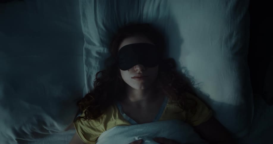 A woman is sleeping with a blindfold