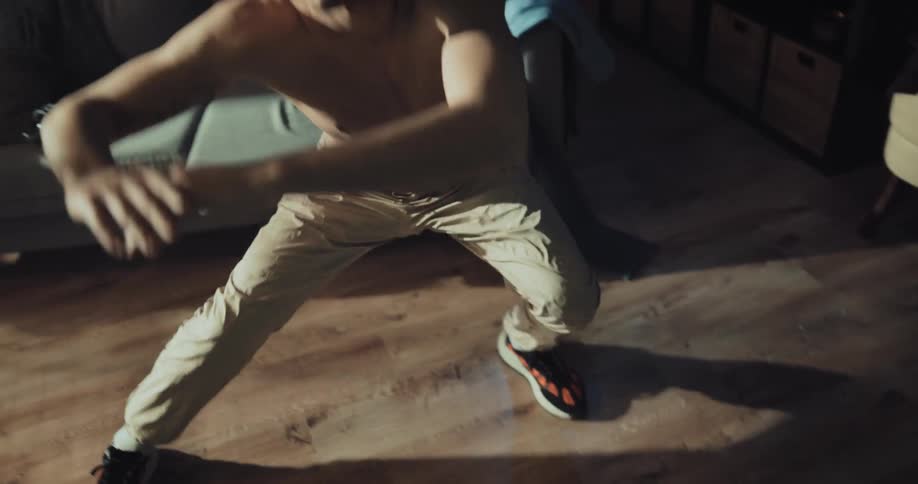Young man working out in the living room while wearing vr goggles