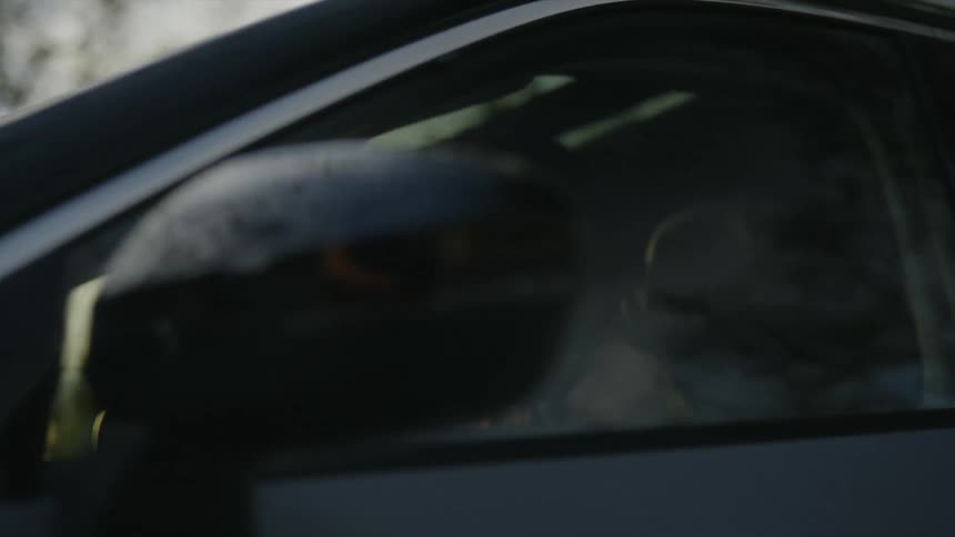 A woman gets in the car fast at sunset