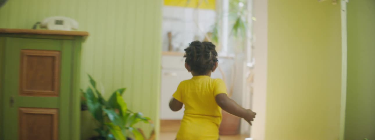 A baby girl walking through a house