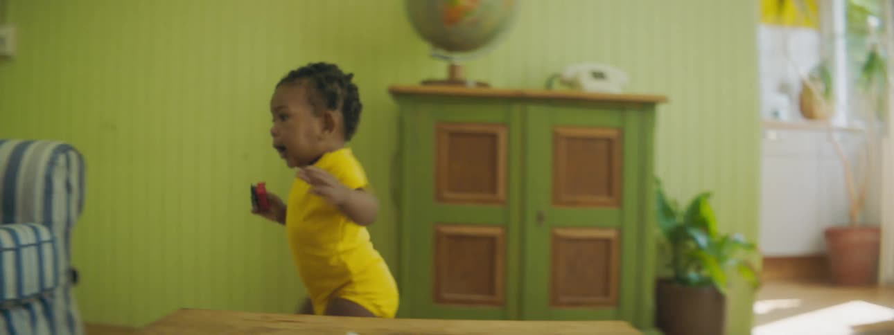 A young baby stumbles over to a couch as theyre learning to walk