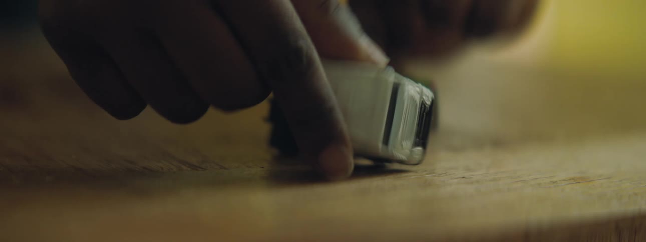 An african american child is playing with diecast toy cars on a brown wooden tabletop