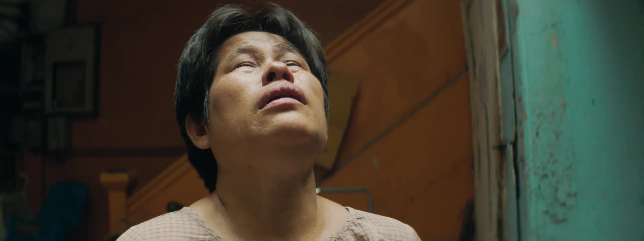Woman standing inside of a building looking up and crying