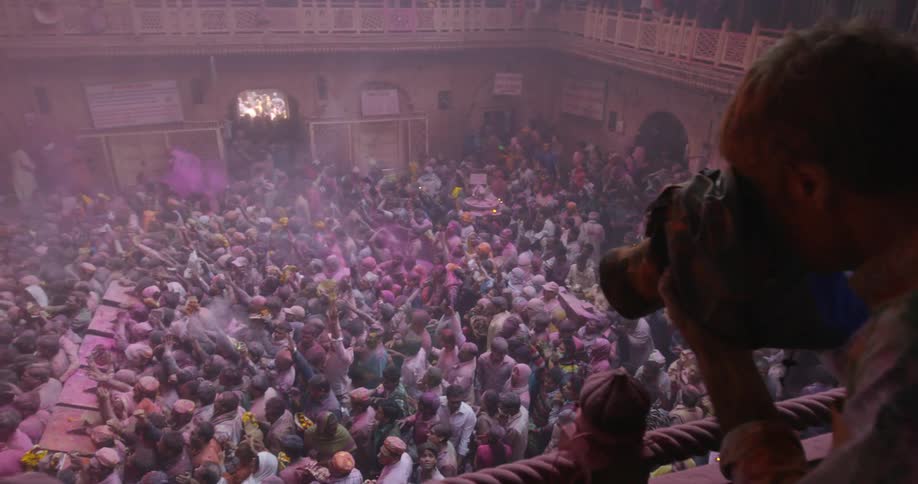 A man takes pictures of a dancing crowd