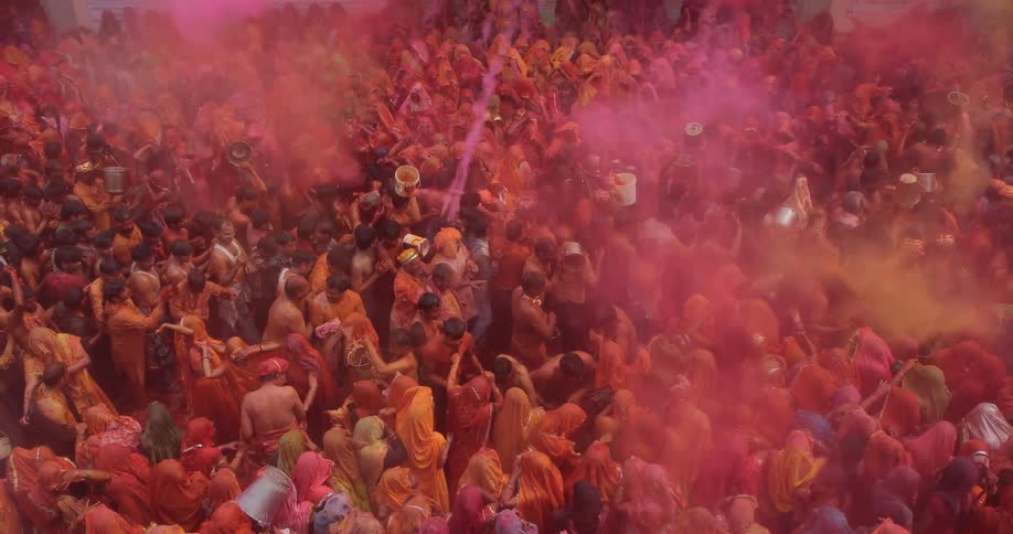 People are celebrating below as clouds of colored dirt drops