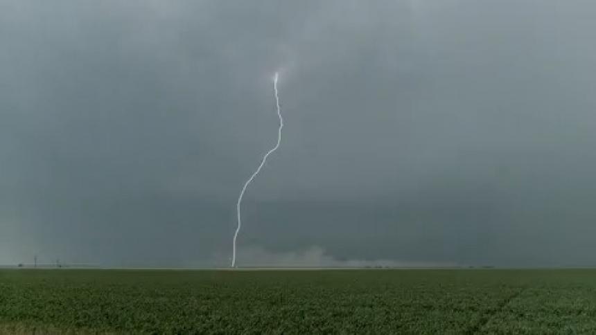 A flash of lightning above a field of grass