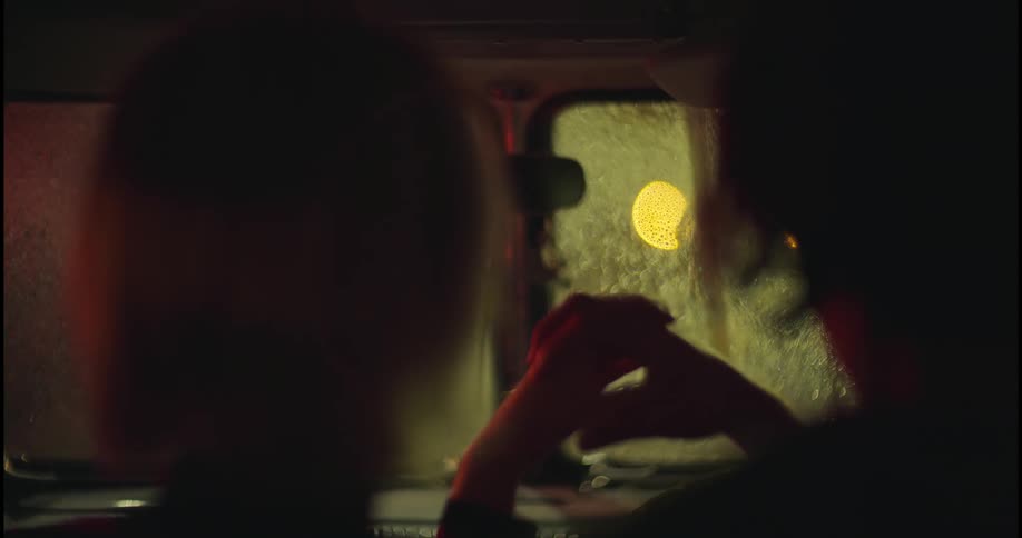 Couple sit in vehicle holding hands