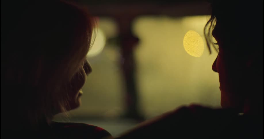 A woman laughs as she talks to a friend sitting beside her as they look out the window
