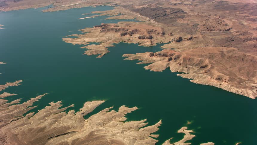 Brown land extending out into the smooth lake water like fingers