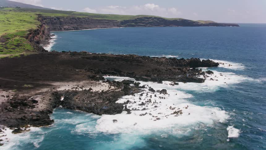 An aerial view of ocean waves crashing in to the shore