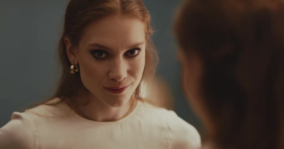 Woman smirks before turning attention to another woman