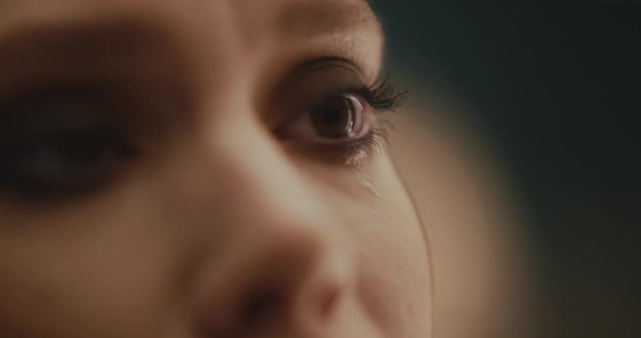 The upper part of a womans face is seen as she moves her brown eyes