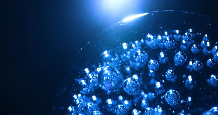 A blue marble filled with air bubbles glows under a blue light
