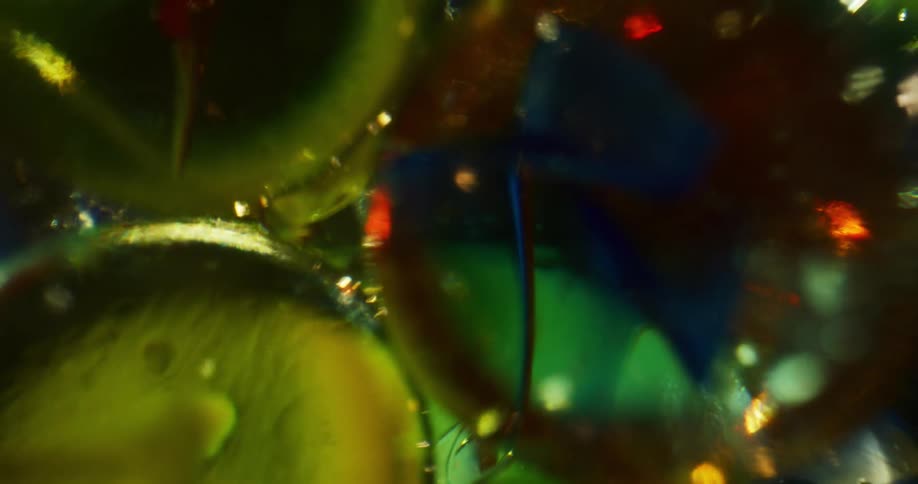 Light shines through a spinning container full of marbles
