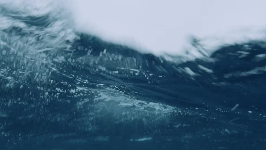 The surface water of the ocean rises and falls while the camera captures some underwater footage