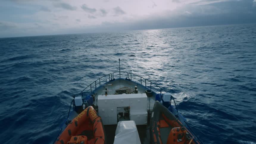 A double decker boat sails through the ocean