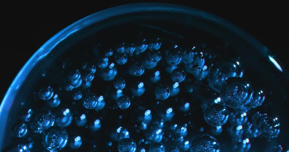 A glass sphere embedded with marbles spins around and around