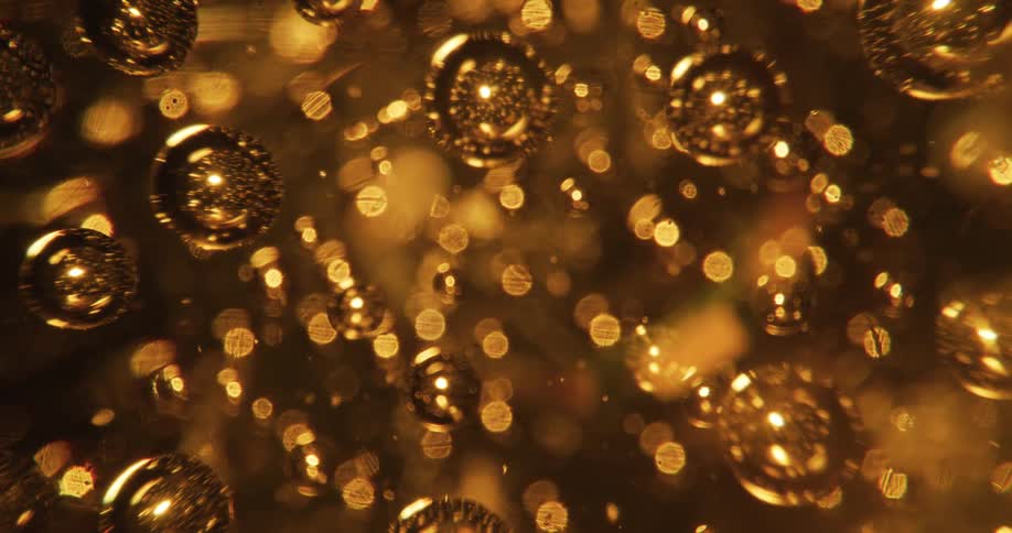 Shiny gold spheres reflect light as they move with golden lights