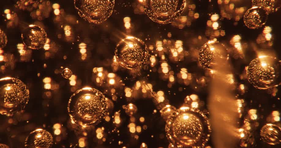 Air bubbles inside a glass globe shimmer and shine like gold