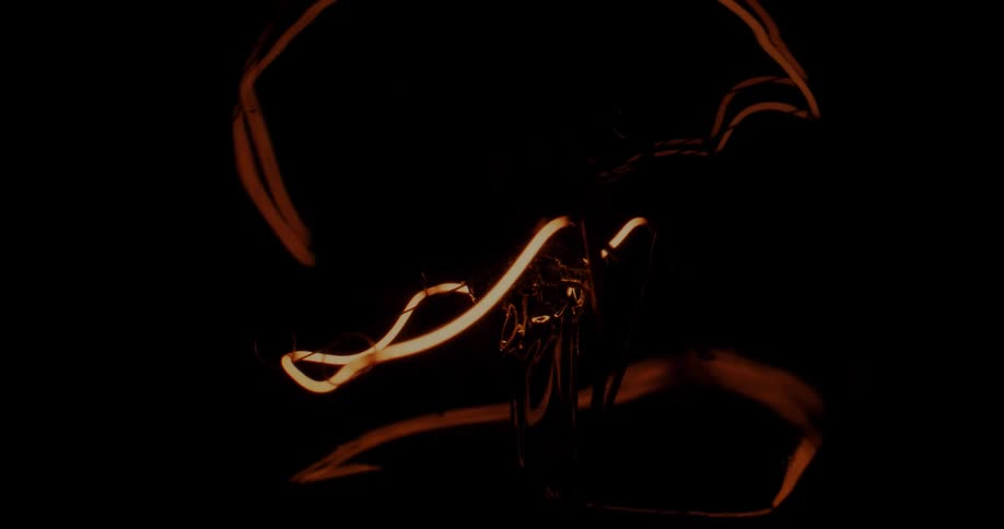 A ribbon of light glows against black then illuminates the darkness