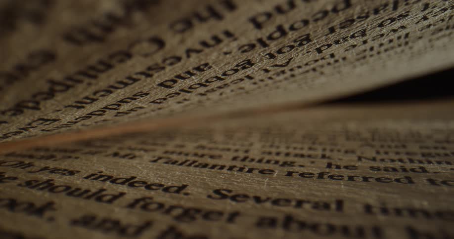 The surface of book pages and text looking textured and bumpy when the light shines